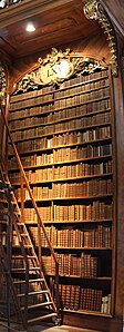 Eines der meterhohen Bücherregale aus Nussbaumholz