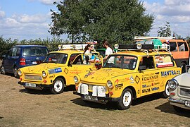 Two yellow cars with their drivers shaking hands