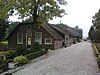 Boerderij, langhuis, laag langgerekt gebouw. Geschoren linden voor het huis