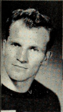 A black and white photograph of a man, shot from the neck up