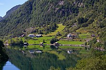 Foto vereinzelter Häusern in einem steilen Terrain an einem Gewässer