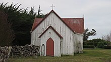 An old wooden church in a grassy area