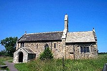 A low church seen from the south, with the nave and a porch on the left, the chancel on the right, and a bellcote on the gable between them