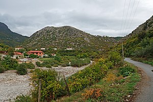 Am Fluss Kir mit dem Burghügel über dem Dorf in der Bildmitte