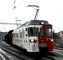 BDe 4/4: 142 met normaalspoor goederenwagens op rolbokken op 8 februari 2007 te Broc-Village naar de melkfabriek van Nestlé