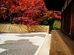 Wooden building with an open veranda next to a raked gravel garden.