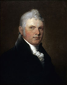 Portrait of an older man with white hair, dark jacket and white cravat in a fancy knot.