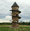 round brick tower with ramp spiralling from ground to roof and goats standing on the ramp