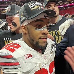 Football player listens to question.