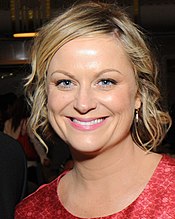 A smiling blond woman wearing a red dress.