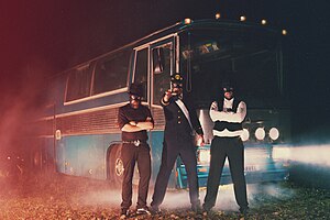 The Märvel trio of the Vicar (left), the King (center), and Burgher (right) in front of their tour bus.