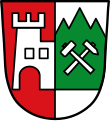 Gemeinde Burgberg i. Allgäu Gespalten von Rot und Silber; am Spalt vorne eine silberne Burg mit offenem Tor, hinten ein grüner Berg mit drei Spitzen, belegt mit einem silbernen Schlägel und einem silbernen Hammer in schräger Kreuzung.