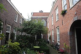 Hofje De Zeven Keurvorsten, rechts de huisjes uit circa 1645, links de 7 huisjes uit 1724, op de achtergrond de oude kapel