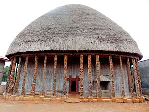 Traditional Bamileke architecture, main hall of the Bandjoun palace in Cameroon, with decoratively carved wooden columns and doorway, unknown architect, unknown date