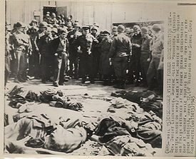 Ο στρατηγός Ντουάιτ Αϊζενχάουερ, όρθιος στο κέντρο, τα χέρια στους γοφούς, κοιτάζει τα πτώματα νεκρών Ρώσων και Πολωνών κρατουμένων σε πρώην γερμανικό στρατόπεδο συγκέντρωσης