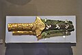 A Mezar Halkası'nda bulunmuş MÖ 16. yüzyıla ait Miken işi, kakmalı bezemeli bronz hançer. Bıçak üzerinde zambaklar tasvir edilmiştir. Kabzasında ve omuzlarında repousse zambakların yer aldığı altın bir kaplama vardır. (Atina Ulusal Arkeoloji Müzesi)
