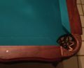 An downward view of a corner pocket of a pool table, showing the leather lattice that forms the pocket. (See "billiard table" for other table types.)