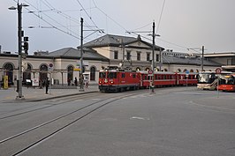 Stationsgebouw van het station Chur met vertrekkende trein van Chur–Arosa-Bahn op het plein