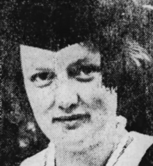 A young white woman with bobbed dark hair, wearing a mortar board cap