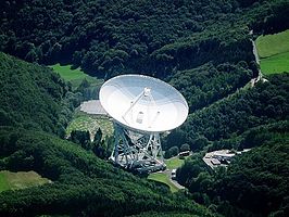 Luchtbeeld van de telescoop met daarachter een meetstation van LOFAR