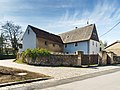 Wohnstallhaus und im Winkel angebautes Seitengebäude eines Bauernhofes, mit Torpfeilern und Einfriedungsmauer