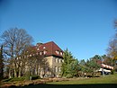 Institut für Züchtungsforschung (ehemaliges Kaiser-Wilhelm-Institut) mit Hauptgebäude, Seitenflügel, Wirtschaftsgebäude, Hof mit Gedenkstele für den Begründer Erich Baur, Direktorenvilla mit Park sowie Wirtschaftshofanlage