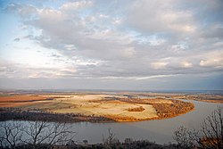 Photo of a flat, agricultural landscape with a blue river curving through the landscape.