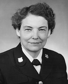 Dorothy C. Stratton, Director of the SPARs, in dress uniform seated at her desk