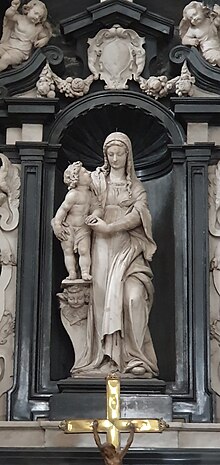 Helle Marmorstatue Madonna mit Kind auf Podest, in dunkler Steinnische mit Tundbogen, umgeben von hellen barocken Marmorelementen