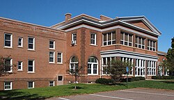 A two-story brick building with a Neoclassical center and plainer wings on either side