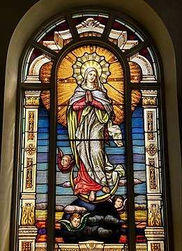 L'incoronata Beata Vergine Maria in cielo raffigurata come la "donna vestita di sole, con la luna sotto i piedi e sul capo una corona di dodici stelle» (Apocalisse 12:1). - vetrata in S. Basilica di San Giuseppe, California, USA, 1921.