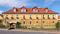 Wohnstallhaus (heute Gaststätte und Pension), Scheune und Taubenhaus eines Vierseithofes, mit Einfriedung und Eingangspfeilern (Försters Gasthof)