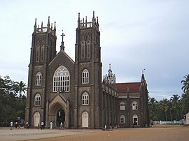 Ornate building in the early morning with a giant order of columns beneath a Latin inscription, fourteen statues on the roofline, and large dome on top.