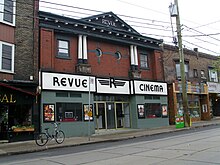 two storey building with large sign Revue Cinema