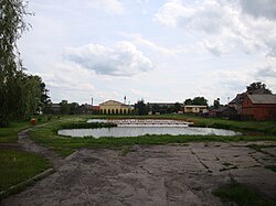 Pond in village, church in background