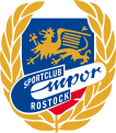 Das Emblem seit 1964. Von 1956 bis 1964 wurde ein ähnliches, ebenfalls auf dem Wappen der Stadt Rostock basierendes Emblem geführt.