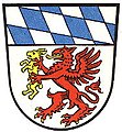 Landkreis Grafenau (–1972) Unter Schildhaupt mit den bayerischen Rauten in Silber ein schreitender und geflügelter golden bewehrter roter Greif, der in den Vorderfängen einen goldenen Hasen hält.[1]