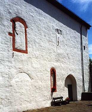 Westwand der Kirche. Man erkennt die vermauerten Fenster des ehemaligen Palas.