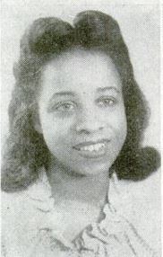 Portrait of a young African-American woman wearing a ruffled scoop-necked blouse and her hair in a 1940s style.