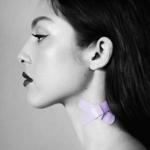 A black and white picture of a female with dark lips and purple Band-Aids crossing her neck