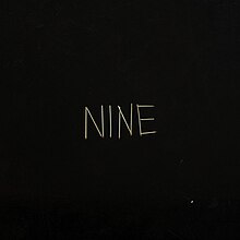 A black background with matchsticks spelling out "NINE" on it