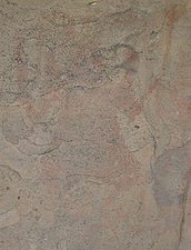 An eroded painting in the caves showing a man dancing and holding a trident-like staff