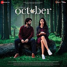 The soundtrack album cover features Varun Dhawan and Banita Sandhu seated on a wood log lying in a jungle. They appear wearing winter-seasoned clothes depicting the month of October. The album title appears at top.