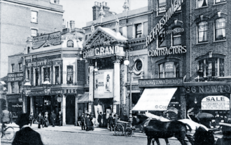 Façade of a theatre with Corinthian columns either side of the entrance and a portico above; a banner with "Green Bushes" is displayed