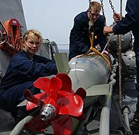 A Mark 46 Mod 5A torpedo is inspected aboard the guided missile destroyer USS Mustin.