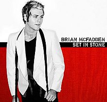 The cover features a black-and-white image of McFadden wearing a blazer, t-shirt and an undone necktie around his neck. The background is white and red, with a black line inbetween them. The artist's name and album title appear beside McFadden, colored in black and white respectively.