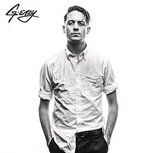 A black-and-white image of a man wearing a wrinkled and half-tucked t-shirt. The artist's logo is placed on the top left of the cover.