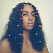 An unclothed woman with hair clips in her hair staring at the camera.