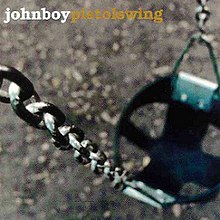 A photo of a playground swing with the focus on one of the metal chains it's hanging from.