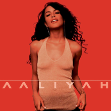 Aaliyah standing in front of a plain red background